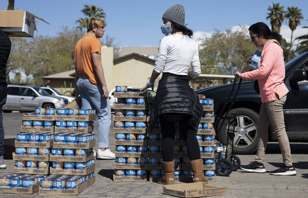 Volunteers hand out food at a food bank hosted by The Just One Project outside Hyde Park Middle ...