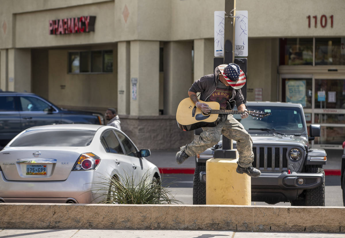 Street musician Kurtis "ToeJam" Nelson plays with plastic gloves on for safety when r ...