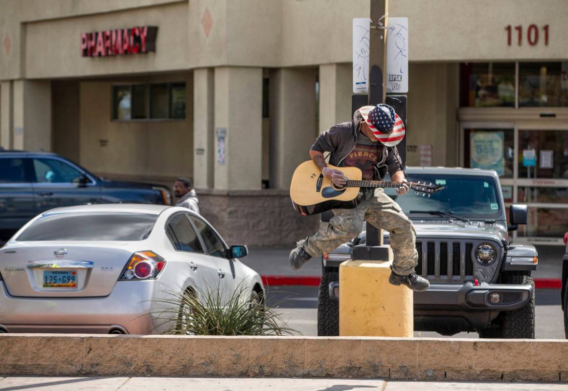 Street musician Kurtis "ToeJam" Nelson plays with plastic gloves on for safety when r ...