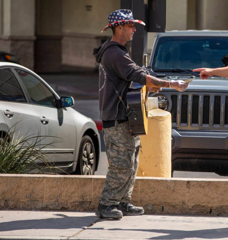 Street musician Kurtis "ToeJam" Nelson plays with plastic gloves on for safety when r ...