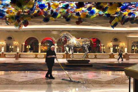 A janitor sweeps up the atrium within the Bellagio as MGM shuts down casino operations at midni ...