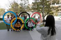 A group of students from Uruguay pose for a souvenir picture on the Olympic Rings set outside t ...