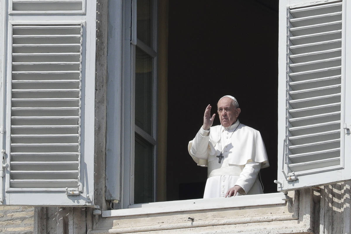Pope Francis delivers his blessing from the window of his private library overlooking St. Peter ...
