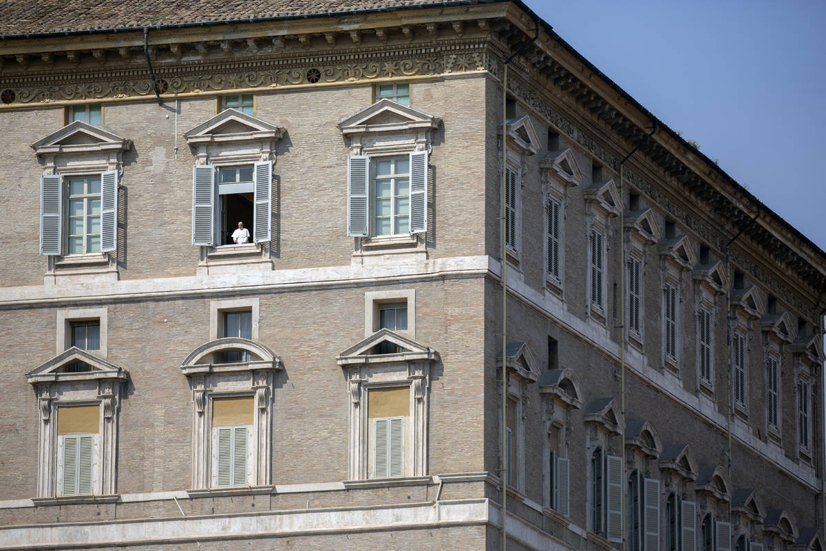 Pope Francis delivers his blessing from the window of his private library overlooking an empty ...