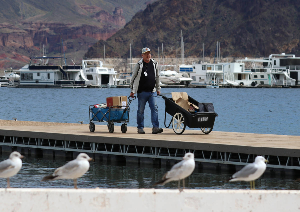 Richard Keeley of Henderson transports his belongings that were retrieved from his boat in cart ...
