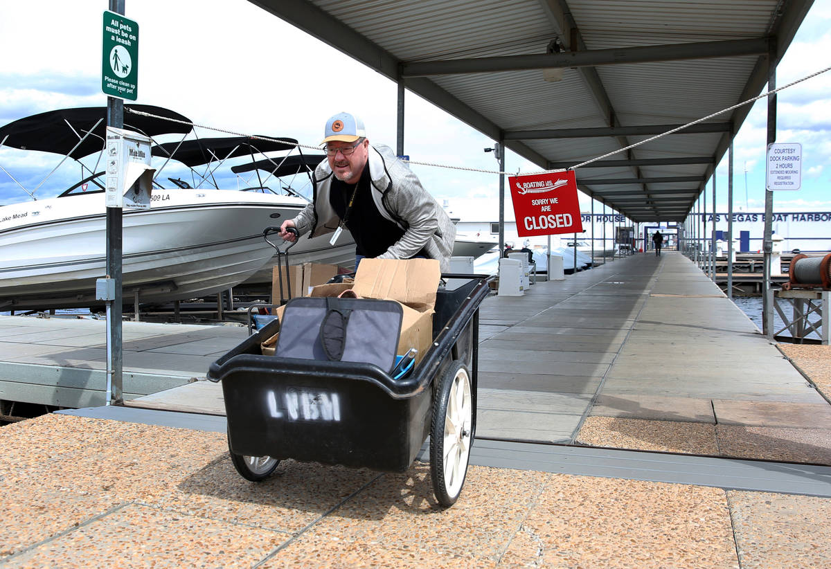 Richard Keeley of Henderson pushes his belongings that were retrieved from his boat at Lake Las ...