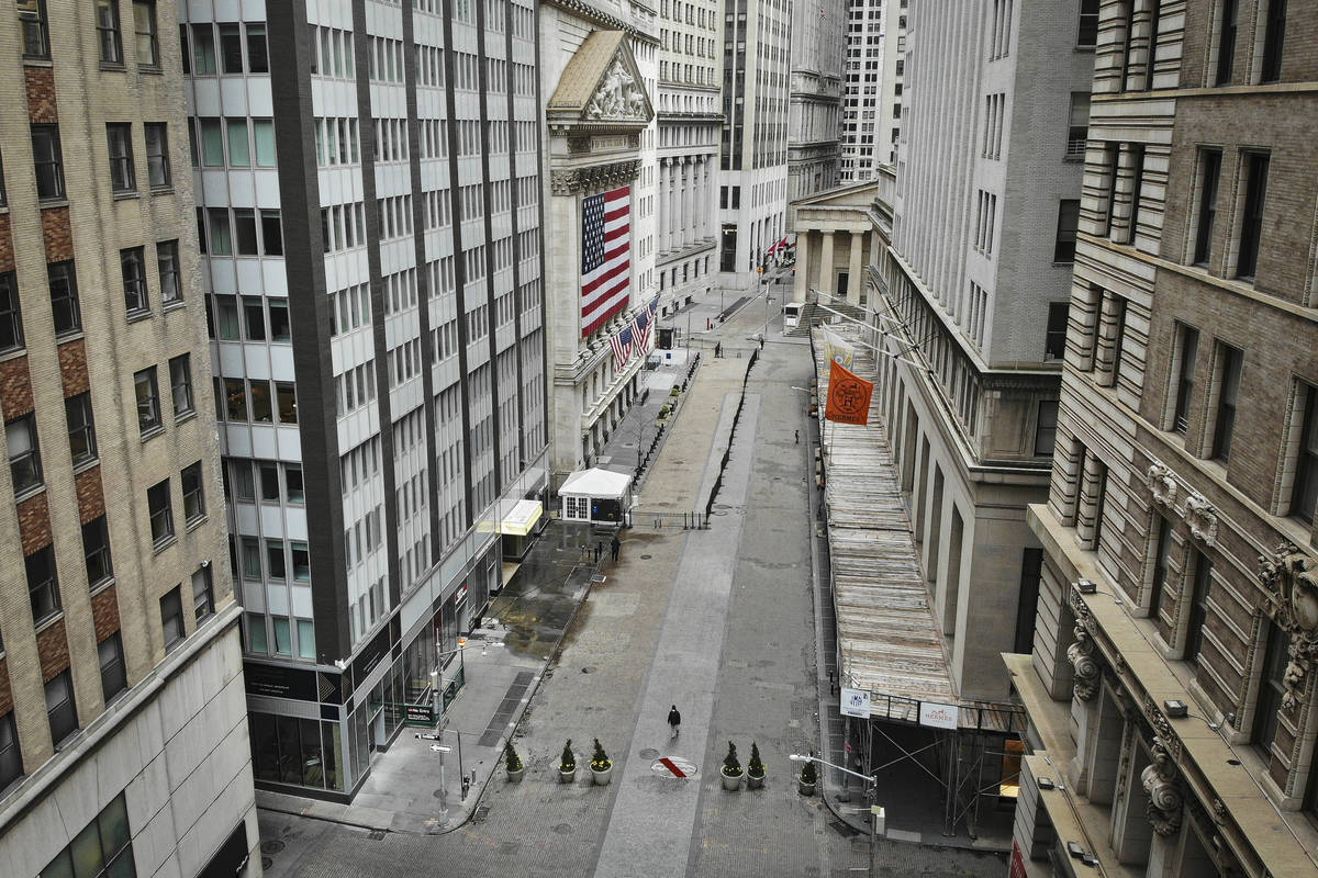 A lone pedestrian walks past the New York Stock Exchange as coronavirus concerns empty a typica ...