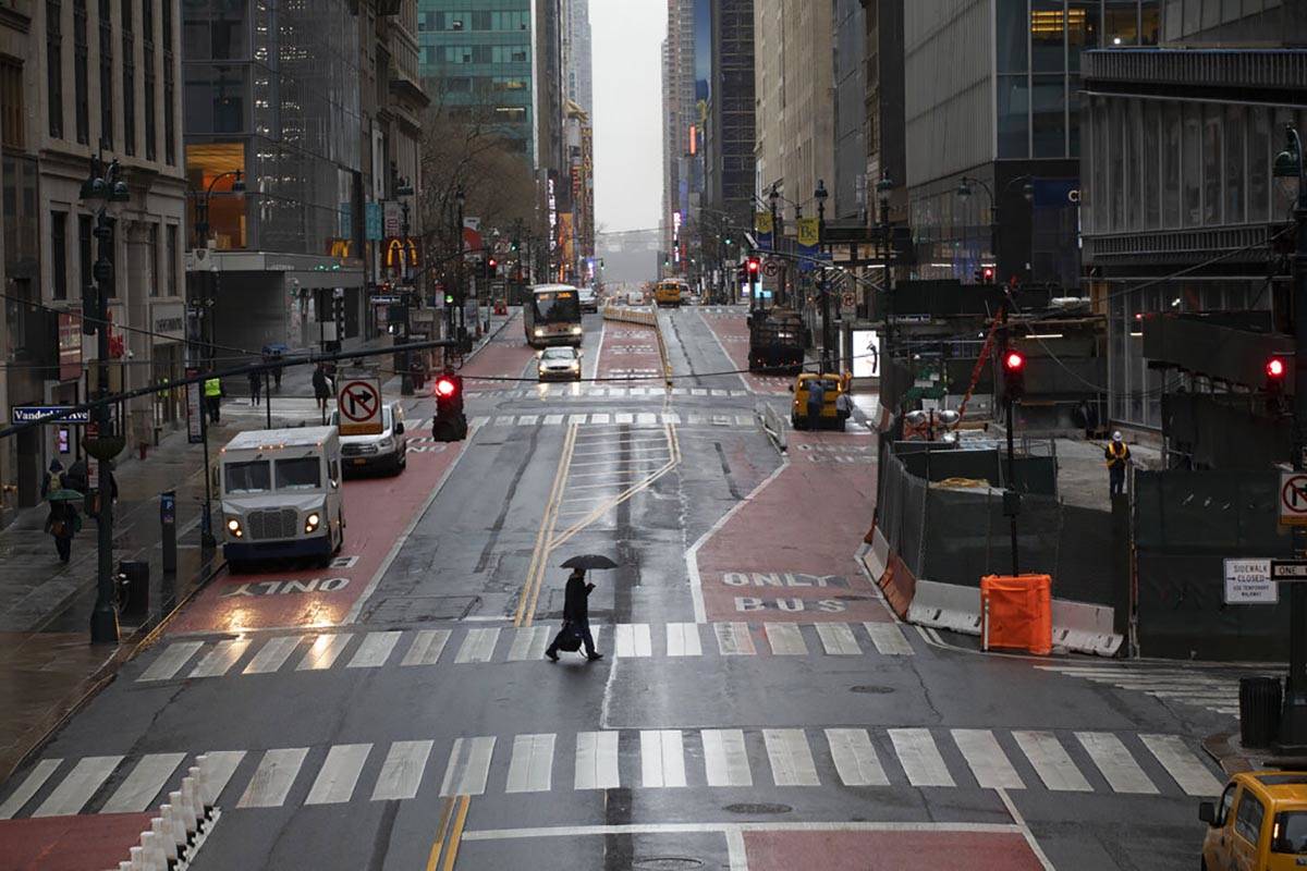 A commuter crosses 42nd Street in front of Grand Central Terminal during morning rush hour, Mon ...