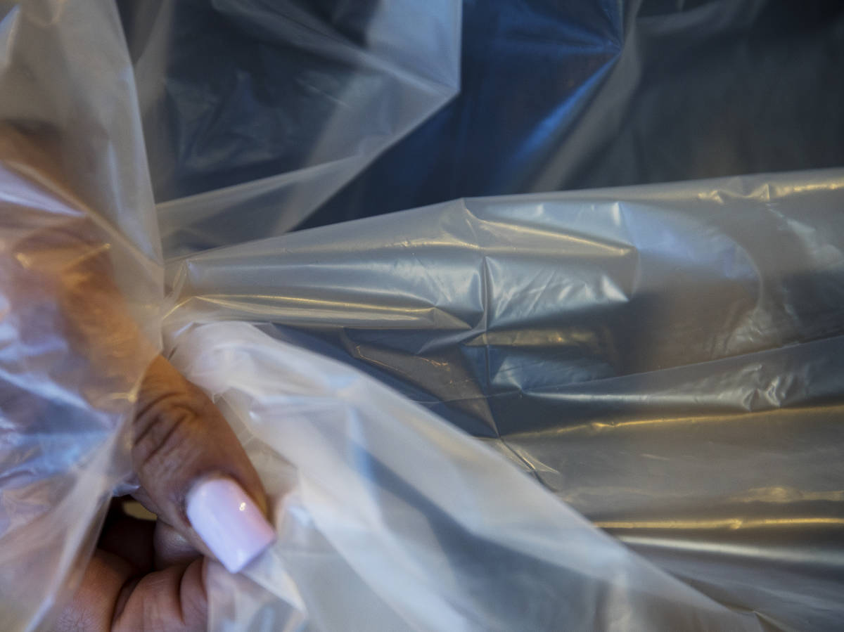 Employee Jordan Mevius shows the polyethylene material for a gown at Polar Shades in Las Vegas, ...