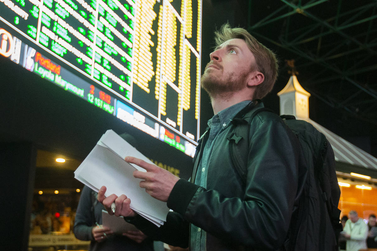 Rufus Peabody, middle, from Boston, Mass., waits in line at Westgate Sportsbook as Super Bowl p ...