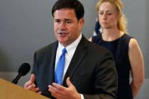 Arizona Gov. Doug Ducey, left, answers a question as he is joined by Arizona Department of Heal ...