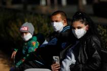 A family wearing face masks enjoy a sunny day at a playground in Prague, Czech Republic, Monday ...