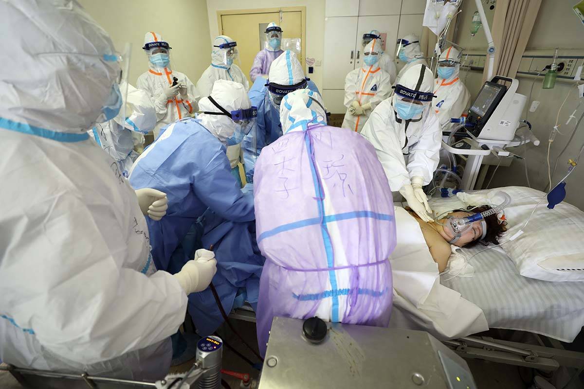 Medical personnel attend to a patient in critical condition at a hospital designated for corona ...