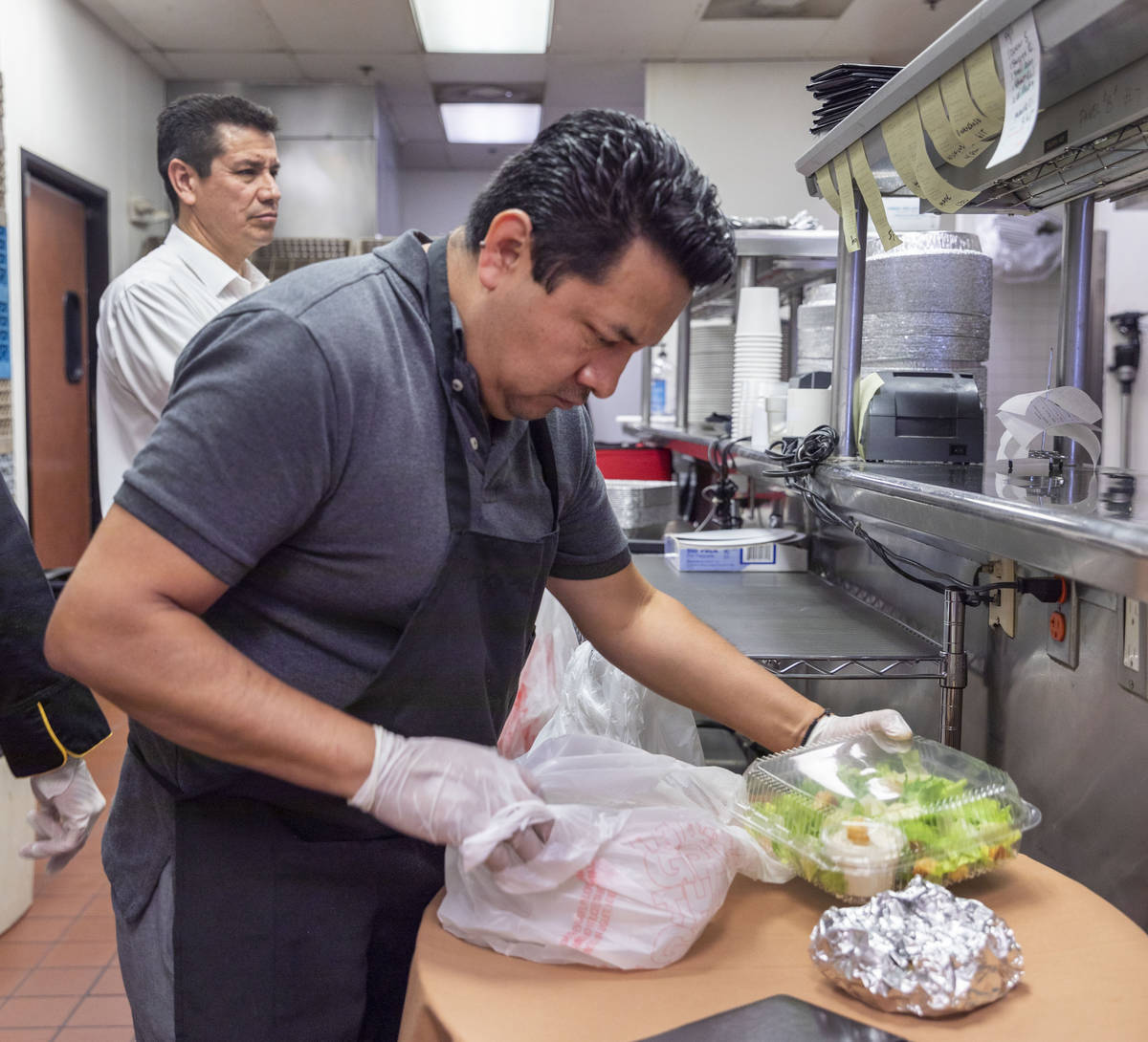 Gaetano's Ristorante waiter Juventino Angeles prepares a to-go order for curbside pickup at the ...