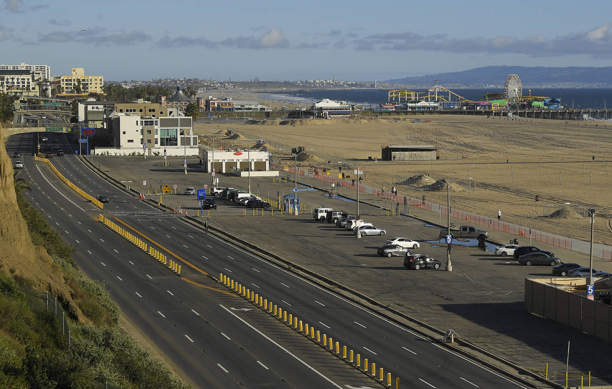Light traffic and a mostly empty parking lot is seen along Pacific Coast Highway, Monday, March ...