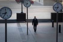 A woman walks in Canary Wharf, during rush hour, in London, Wednesday March 25, 2020. For most ...