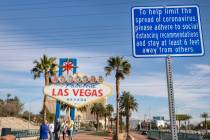 A sign is seen recommending social distancing as tourists from Sydney, Australia take photos un ...