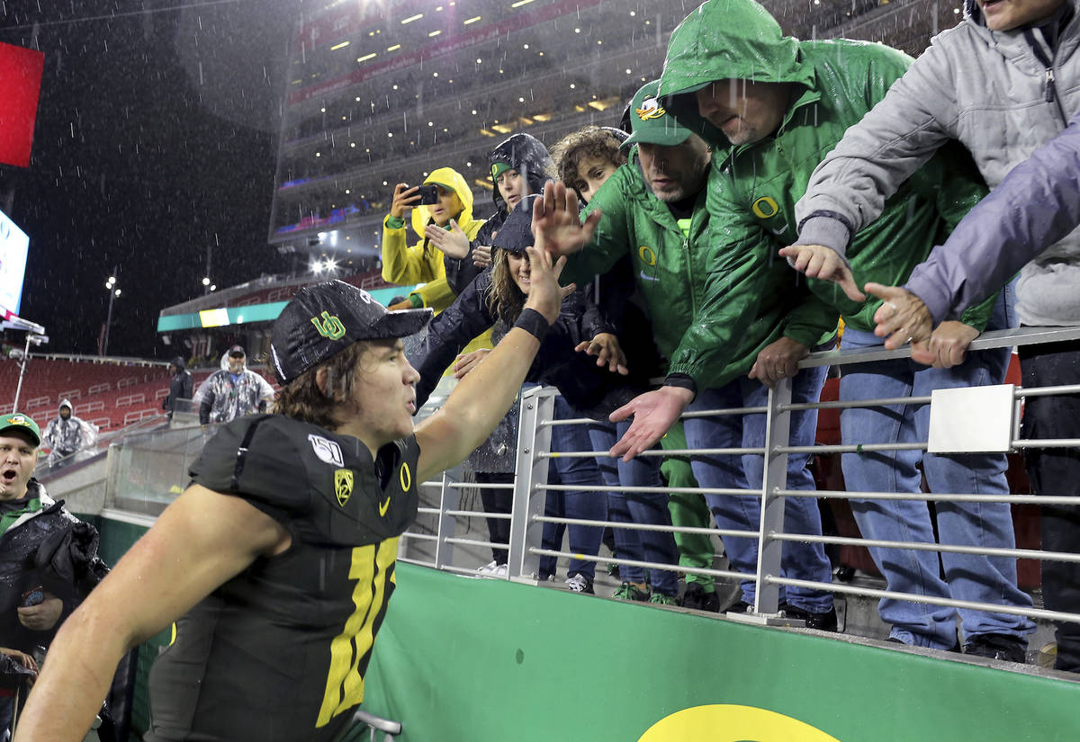 Oregon quarterback Justin Herbert (10) celebrates with fans after defeating Utah 37-15 in the P ...