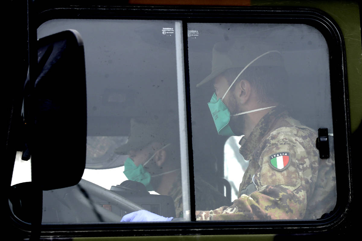 Military trucks moving coffins of deceased people leave the cemetery of Bergamo, one of the are ...