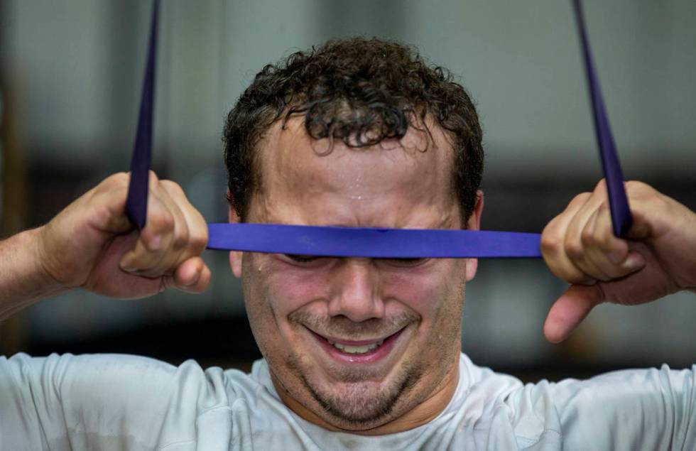 Las Vegas Raiders fullback Alec Ingold pulls a resistance band down to touch his forehead at Sp ...