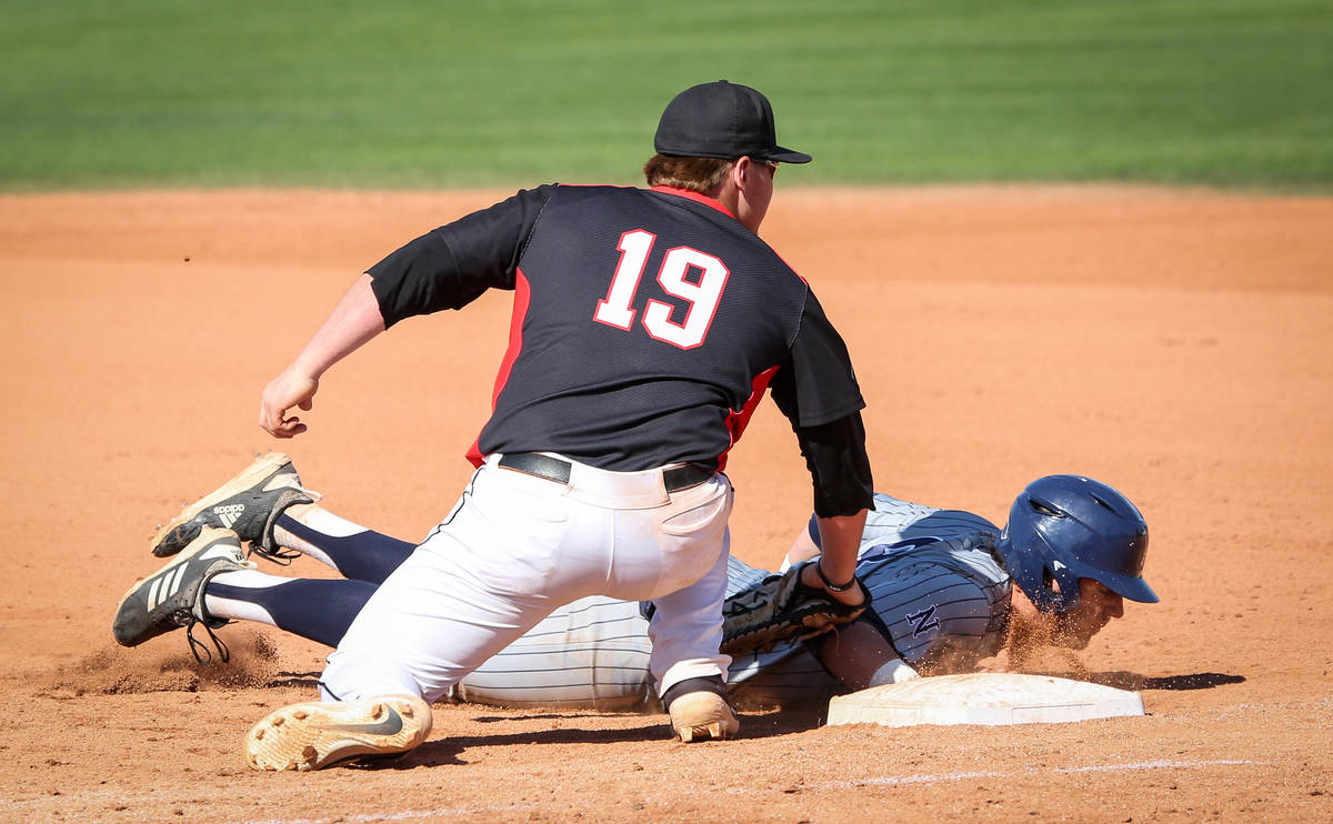 UNR infielder Joshua Zamora (8) slides safely into first base while under pressure from UNLV fi ...