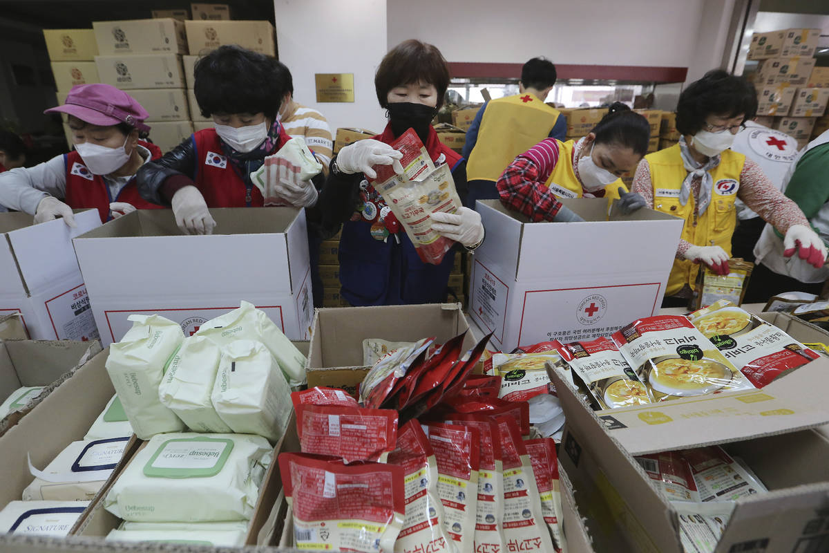 Red Cross workers prepare emergency relief kits packed with basic necessities including instant ...