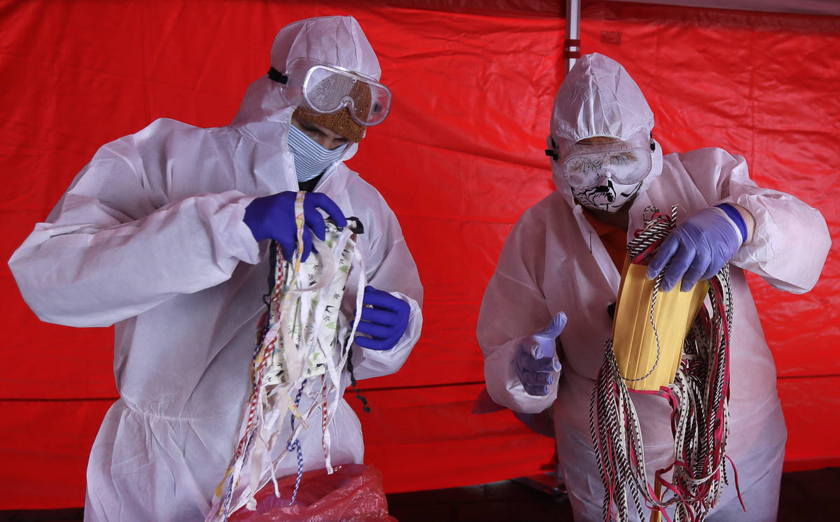 Volunteers with the Red Cross sort homemade face masks meant to be sterilized and distributed a ...