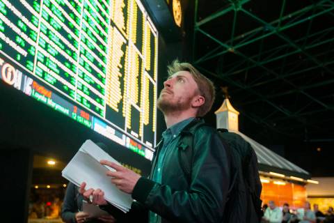 Rufus Peabody, middle, from Boston, Mass., waits in line at Westgate Sportsbook as Super Bowl p ...