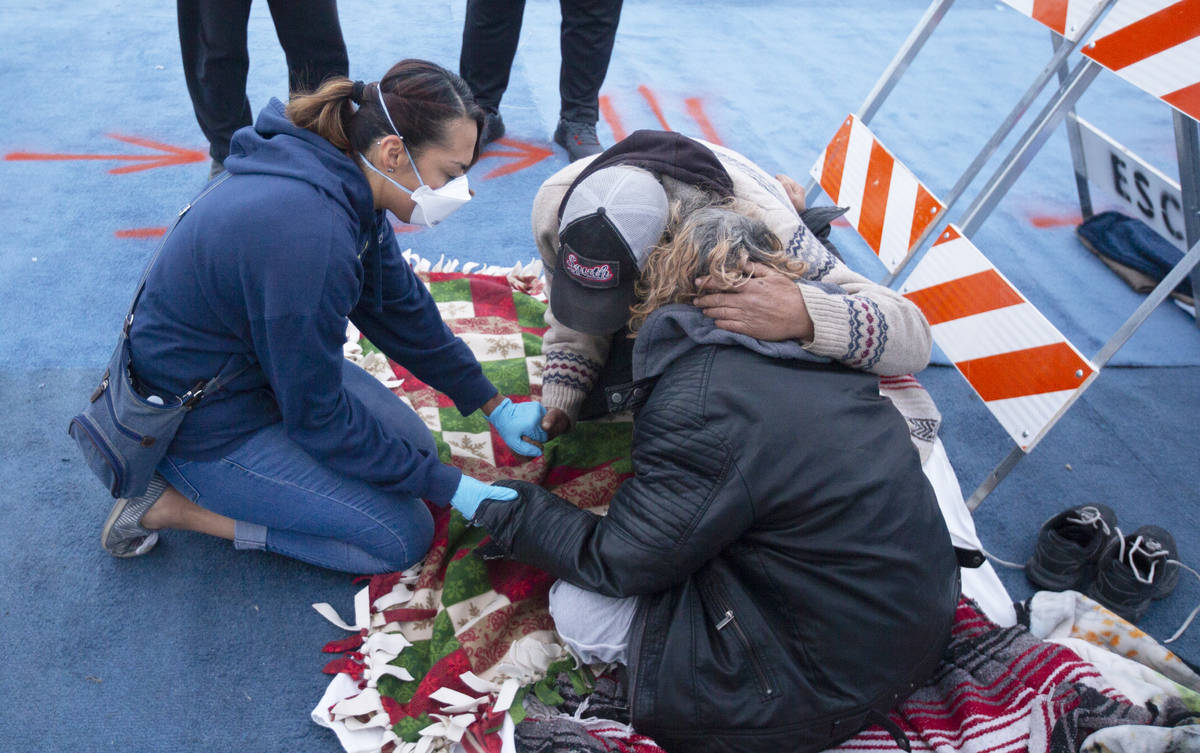 Katherine Kintner, with Messages of Faith Ministry, leads a homeless couple in prayer at a temp ...