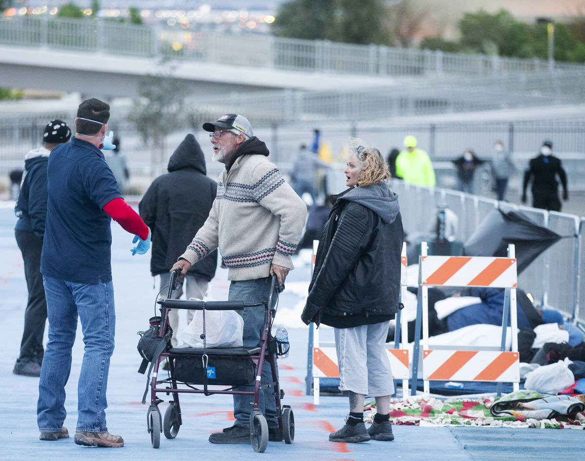 Volunteers help the homeless find places to lay down at a temporary shelter at the upper parkin ...