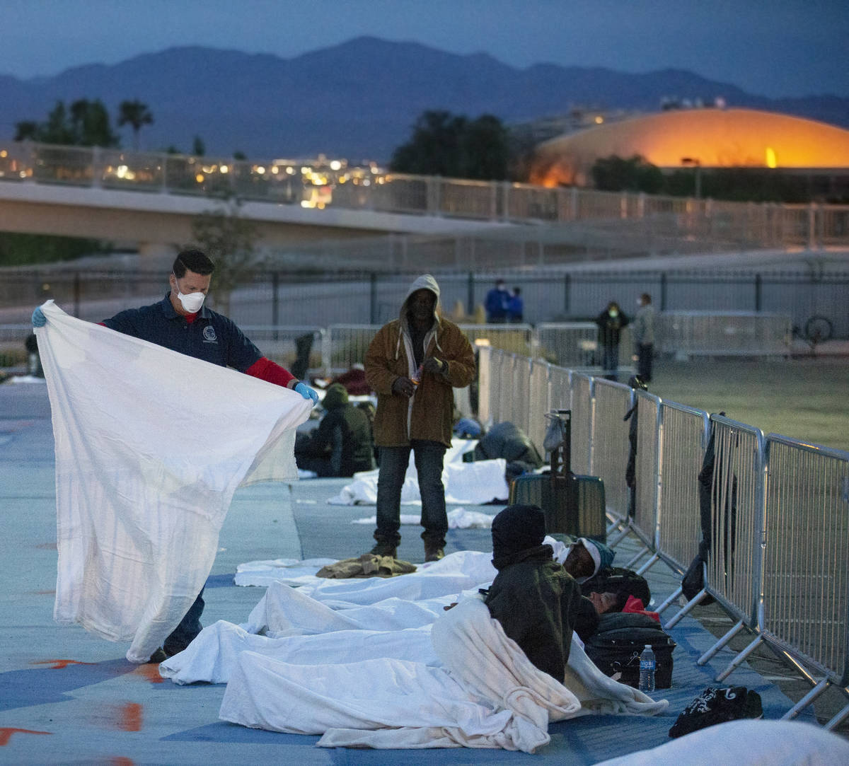 Volunteers provide extra blankets to the homeless at a temporary shelter at the upper parking l ...