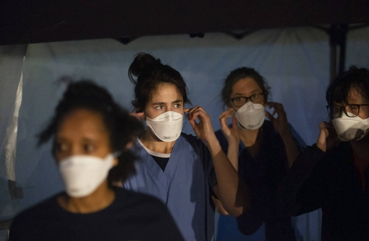 Touro University Nevada medical students work in a coronavirus screening station at a temporary ...