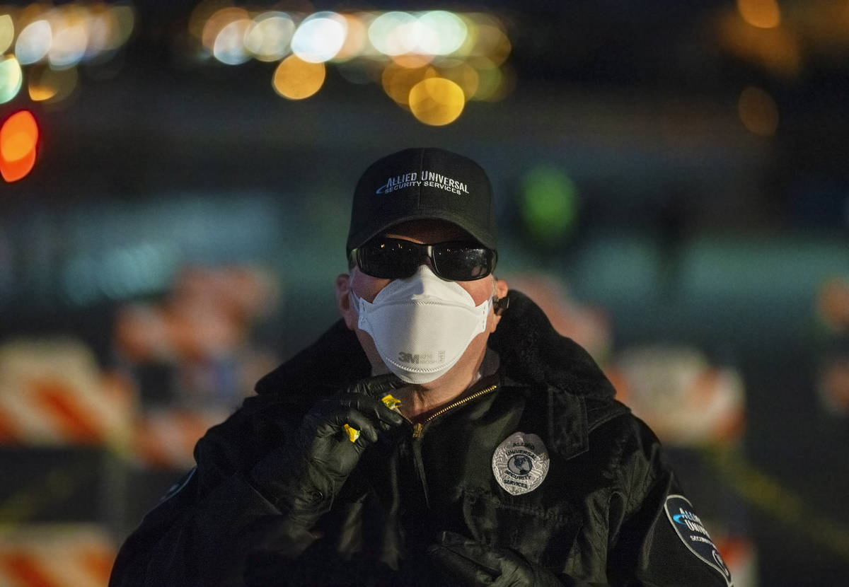 Allied Universal Security officer Jeff Reinharcz guards the entrance to a temporary shelter for ...