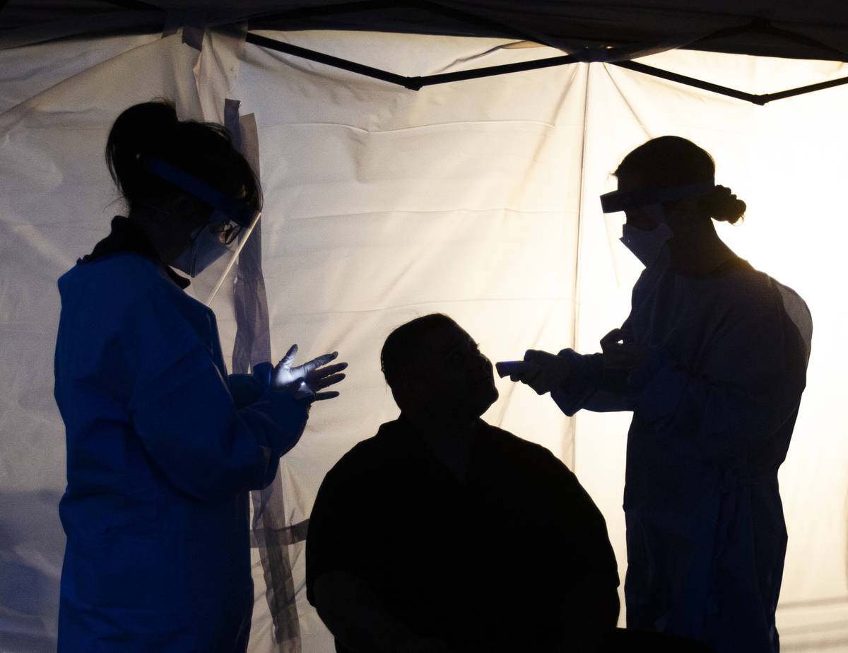 Touro University Nevada medical students work in a coronavirus screening station at a temporary ...