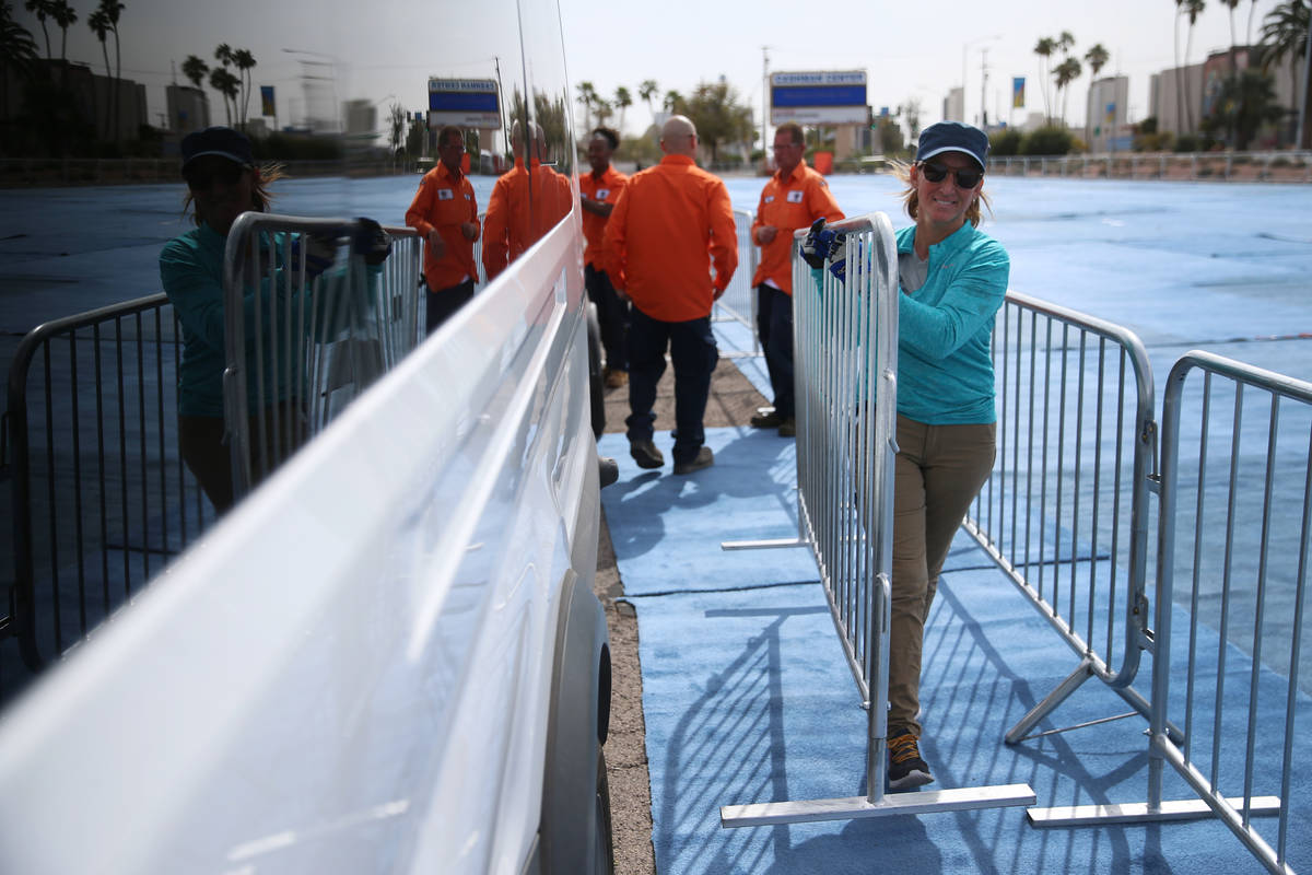Rhonda Giannini, volunteer with Teamsters Local 631, helps to set up barriers for a temporary h ...