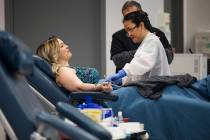 Donor Care Technician Lourdes Ambrocio, right, prepares Mary Beth Atanasiu, left, to give blood ...