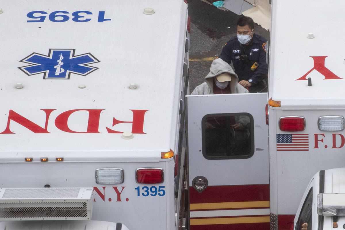 A paramedic transports a patient into the Trauma Center at the Elmhurst Hospital Center, Sunday ...