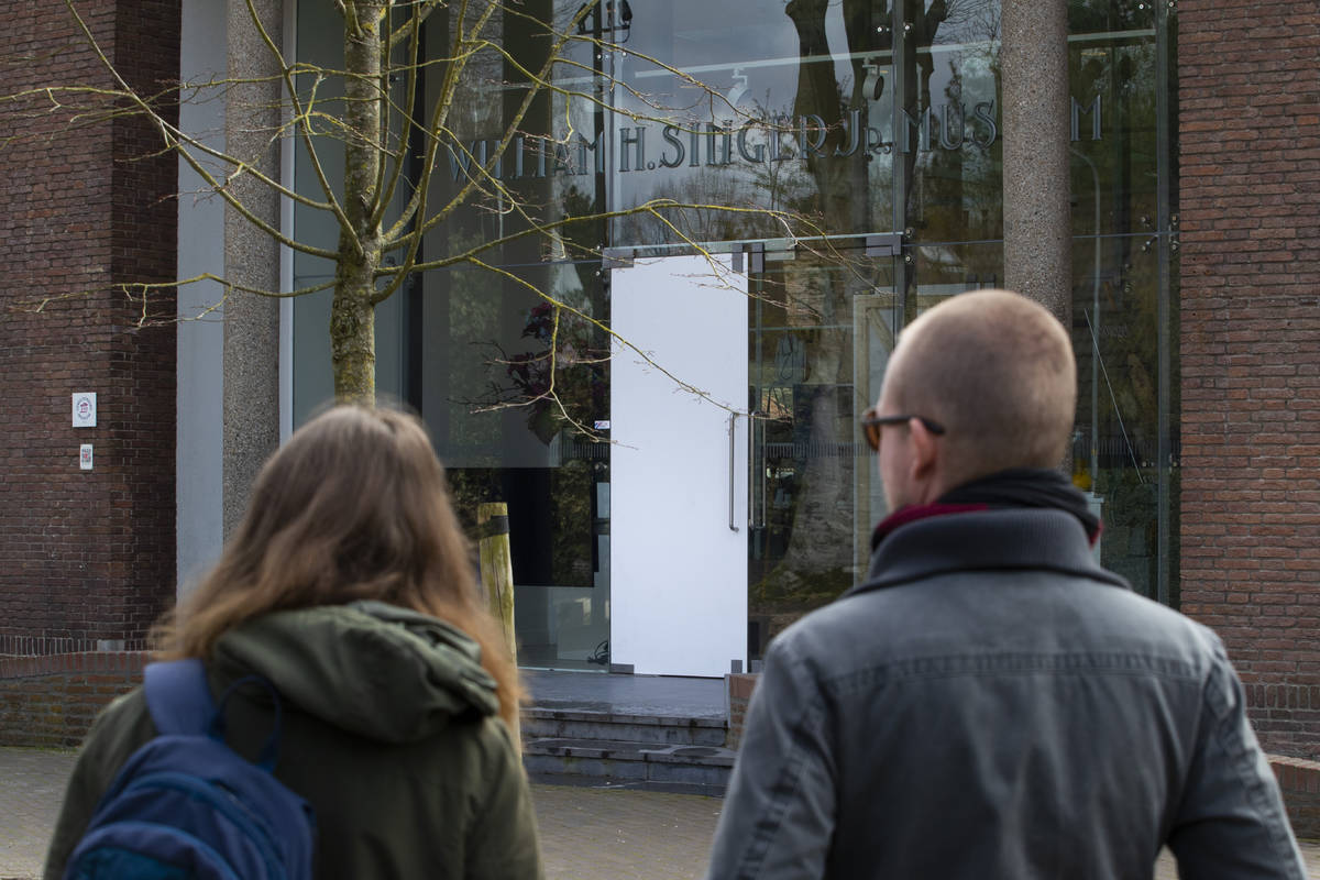Two people look at the glass door which was smashed during a break-in at the Singer Museum in L ...