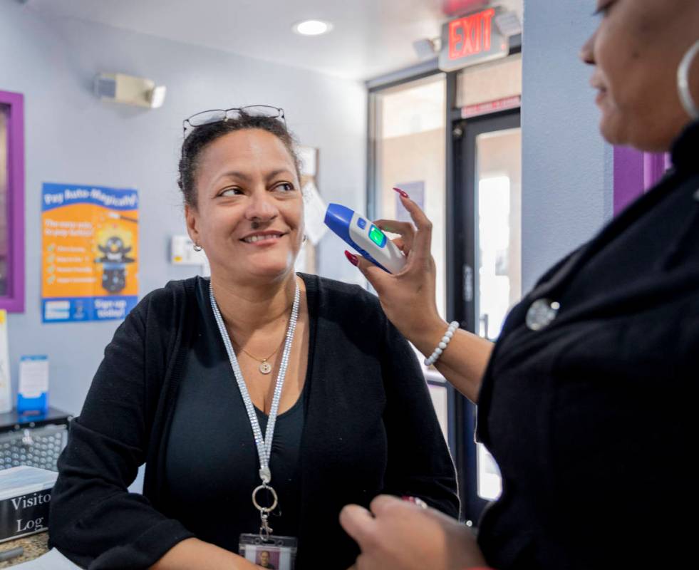 Discovery Gardens Childcare staff member Martha Valenzuela gets her temperature taken at the Bo ...