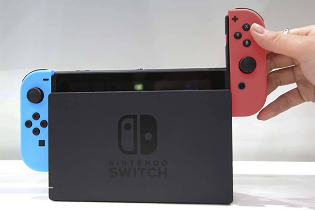 In this Friday, Jan. 13, 2017, file photo, a model puts the controller onto the Nintendo Switch ...