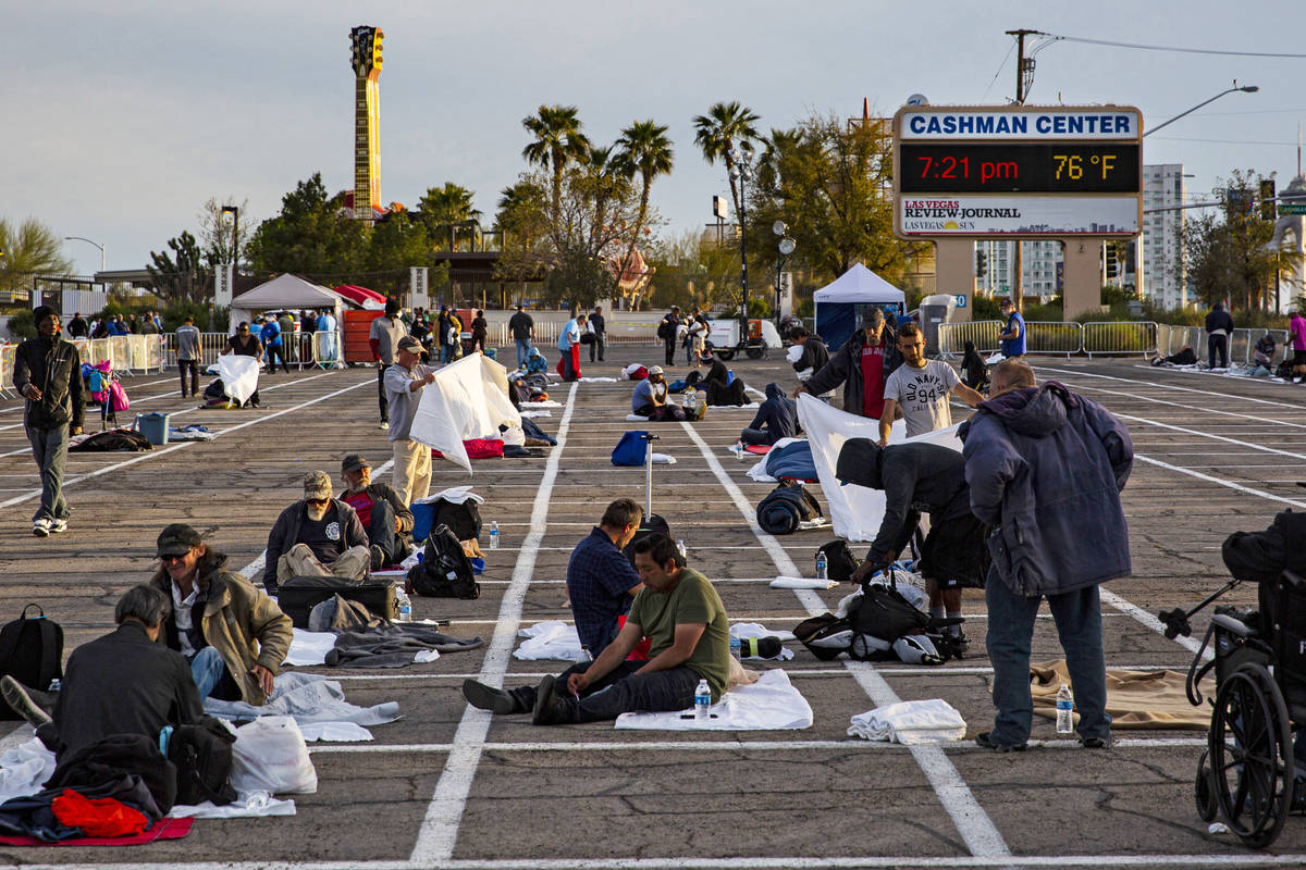Homeless people get set up in their individual spaces at a temporary shelter in the upper parki ...