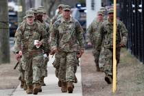National Guard personnel march in formation as they leave duty after working Thursday, March 19 ...