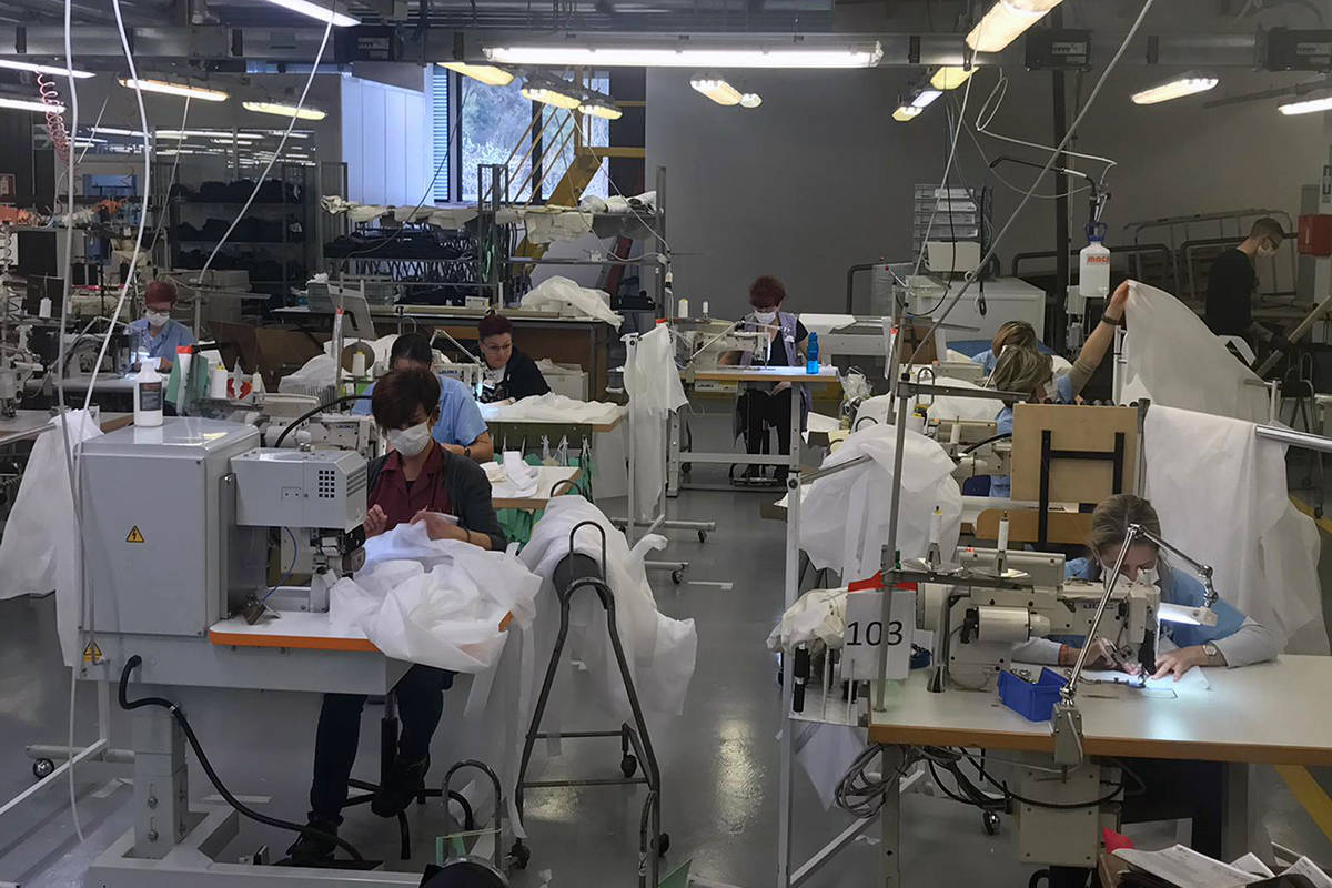 In this photo released Monday, March 30, 2020, workers at the Armani factory in Trento, Italy, ...