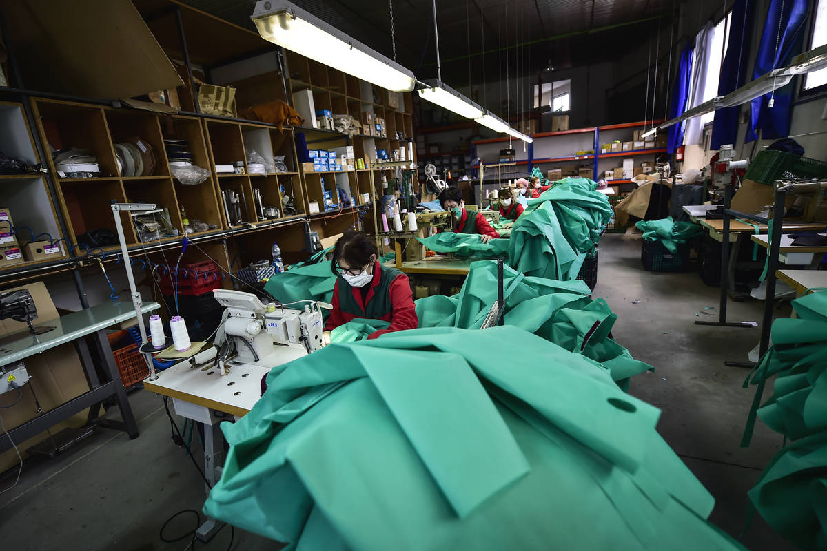Volunteer workers in a clothing factory manufacturing firefighting gear, make hospital gowns fo ...
