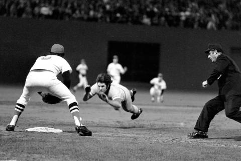 Pete Rose of the Cincinnati Reds is shown diving into third base in the ninth inning of Game 7 ...