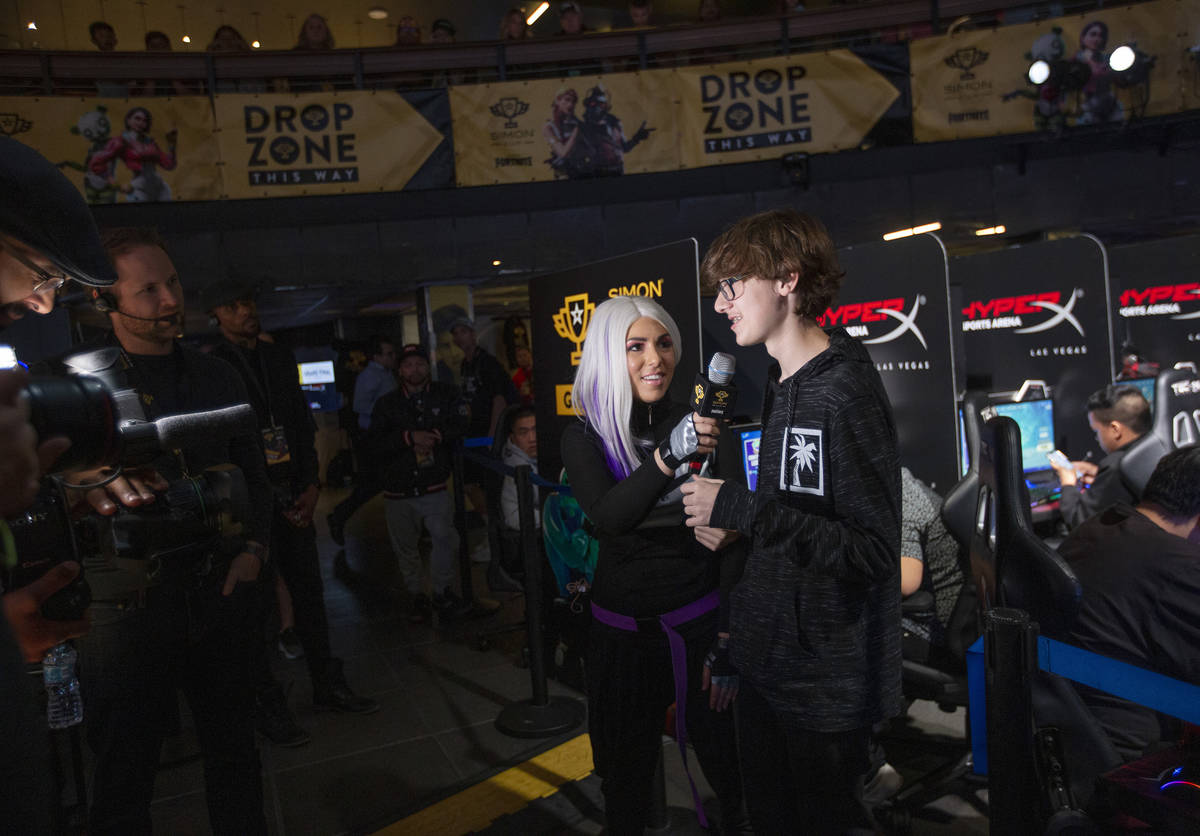 Nikolas Bruno, right, of Las Vegas, is interviewed after winning a game of Fortnite in the firs ...