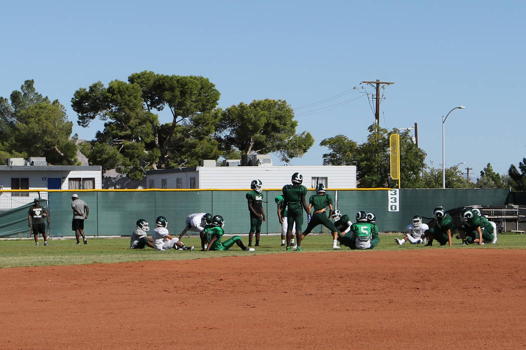 The Rancho High School football team stretches in the outfield of the school's baseball field i ...