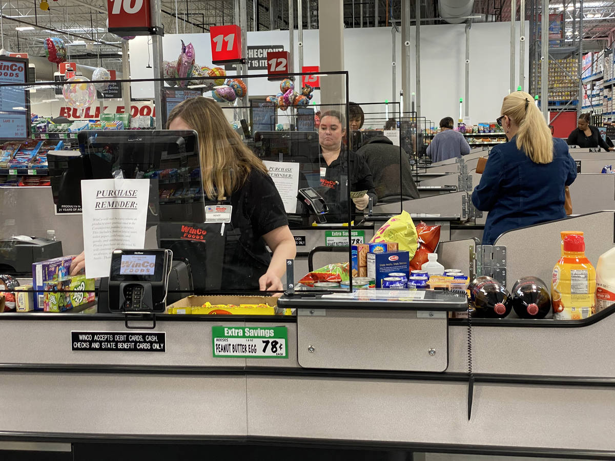Cashiers work behind barriers at WinCo Foods at 7501 Washington Ave. in Las Vegas Tuesday, Marc ...