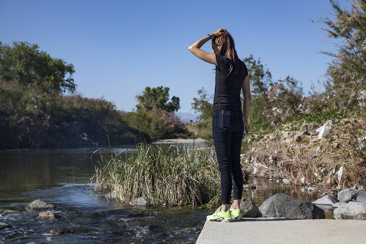 Wendy Cox looks through debris on the side of the wash on the East Side looking for her partner ...