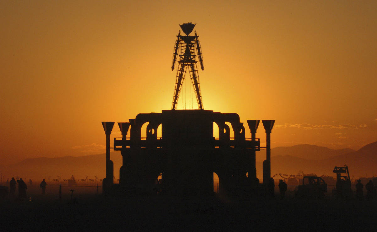 "The Man," a stick figured symbol of the Burning Man art festival, is silhouetted against a mor ...